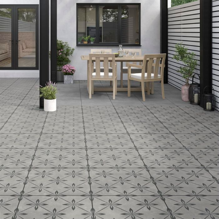 Outdoor dining area on grey tiled patio with wooden table and chairs