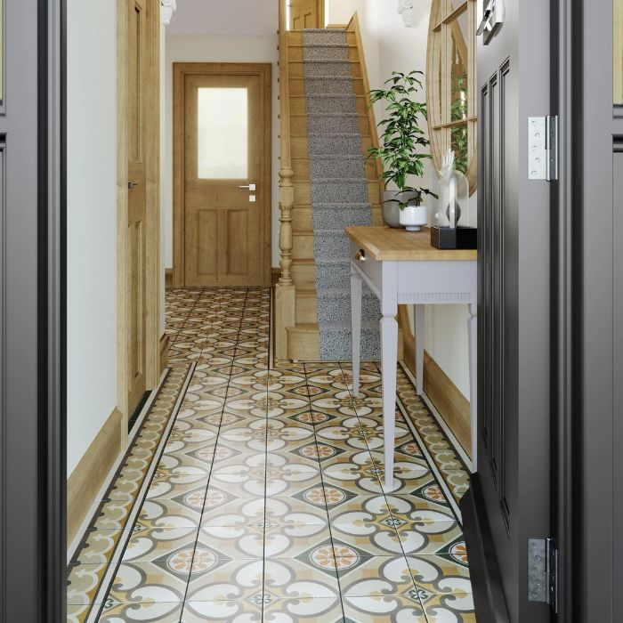 A warmly lit hallway with a classic wooden door, complemented by decorative floor tiles