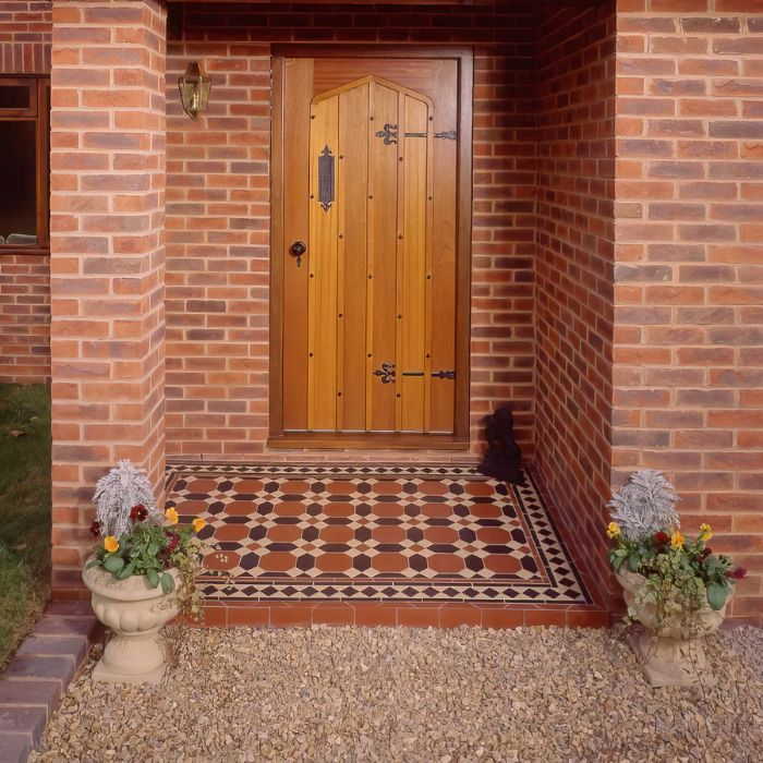 A stylish front door set against a vibrant tiled floor with intricate patterns