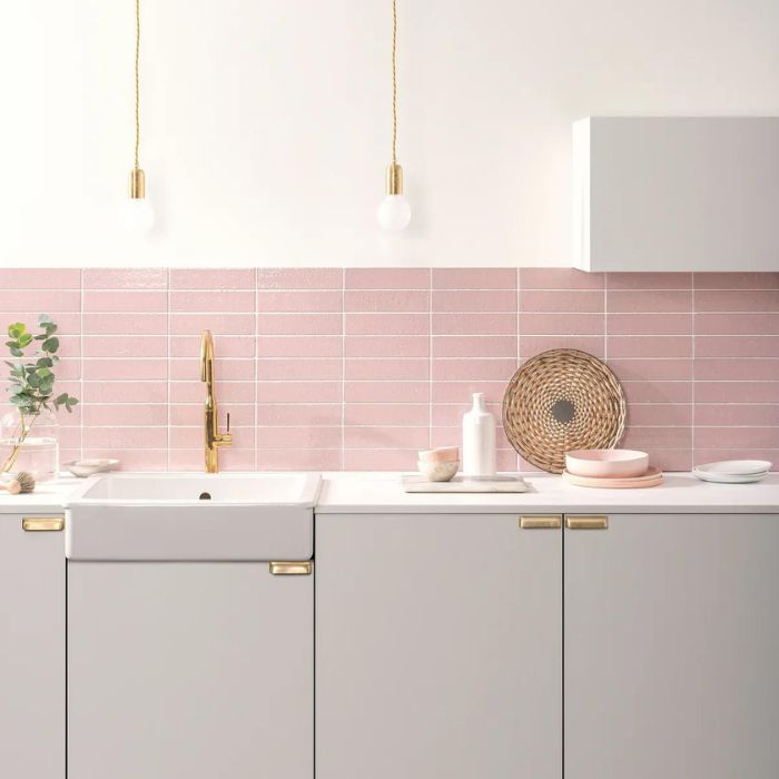 Sleek kitchen interior with rosy pink tiles and glamorous gold fixtures