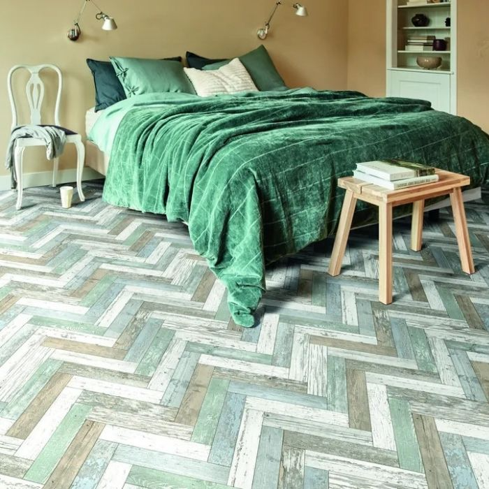 Cosy bedroom with rich wooden flooring, complemented by a green bed 