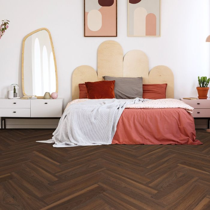 Inviting bedroom with herringbone wood floor and bed