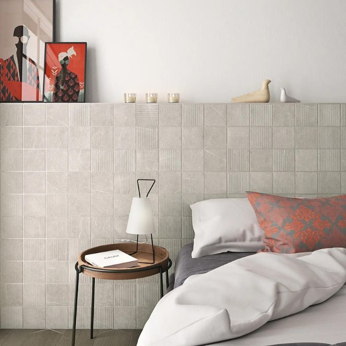 Grey-tiled bedroom interior showcasing a bed and a chic bedside table arrangement