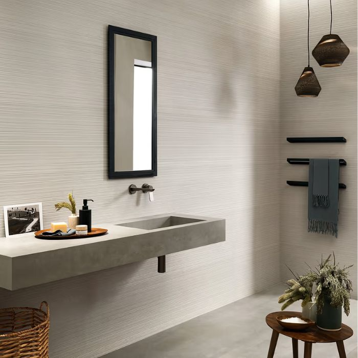 Contemporary space with textured white tiling throughout, complemented by a modern sink