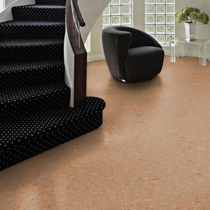 Staircase with black carpet and cork flooring