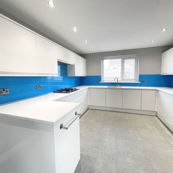 Vibrant blue glass backsplash in a modern kitchen