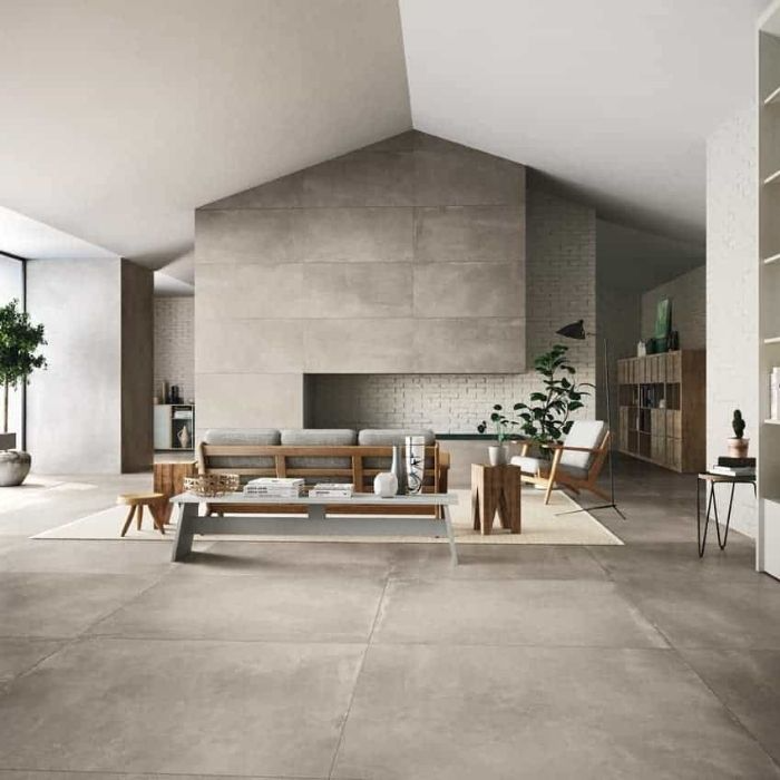 A modern living room featuring grey walls and furniture, complemented by stylish floor tiles