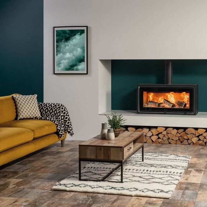 A snug lounge featuring a wood burning stove, where the wooden flooring adds warmth and character to the room