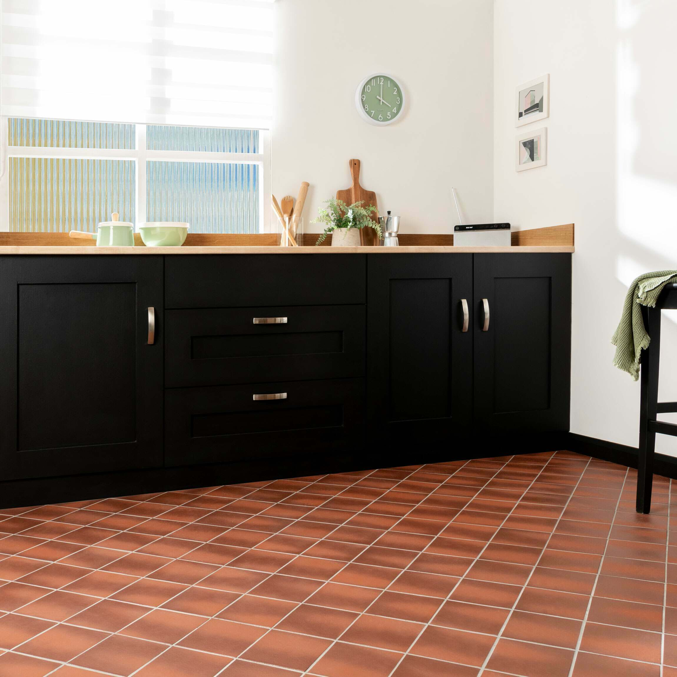 Trendy kitchen decor with black cabinets and terracotta tile flooring