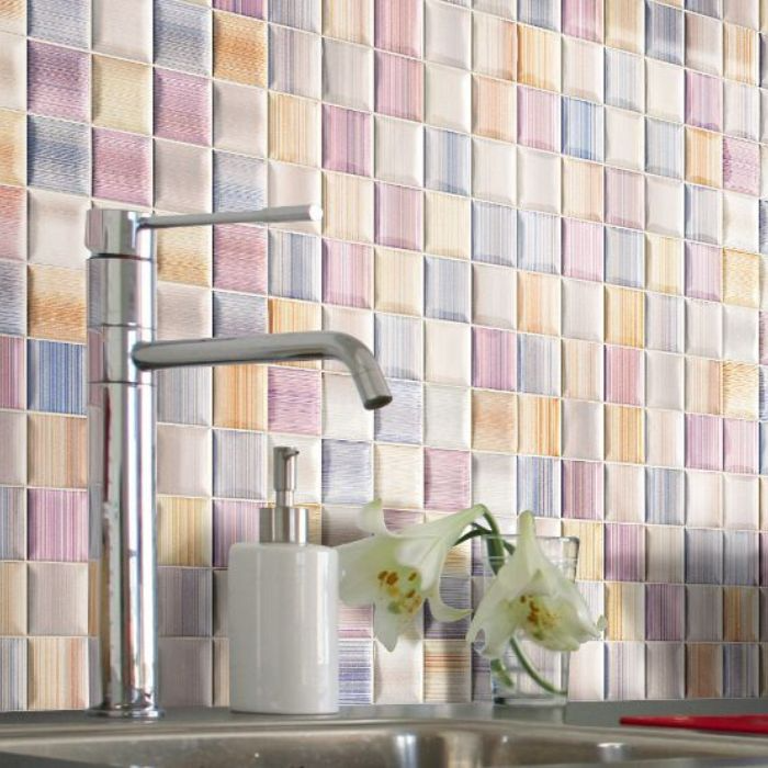 A bright kitchen featuring a vibrant mosaic tiled backsplash that adds character