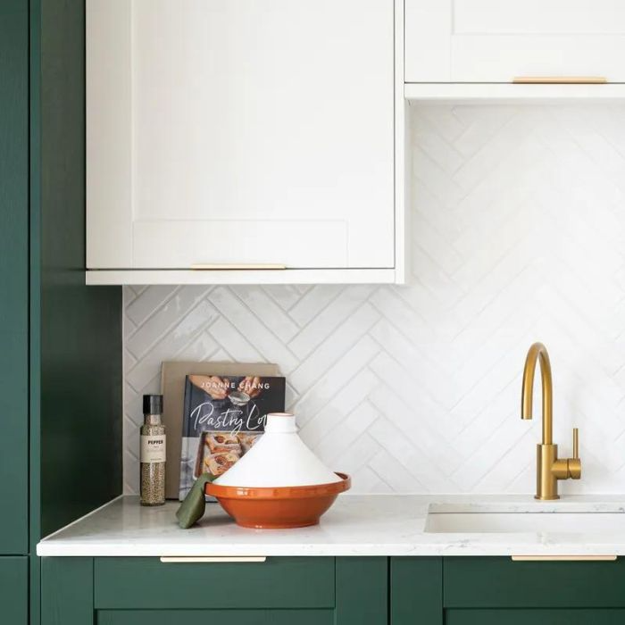 Contemporary kitchen setup with eye-catching green cabinets and sophisticated gold fixtures