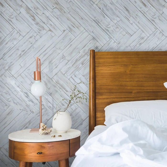 Bedroom with wooden headboard and light-coloured herringbone wall tiles