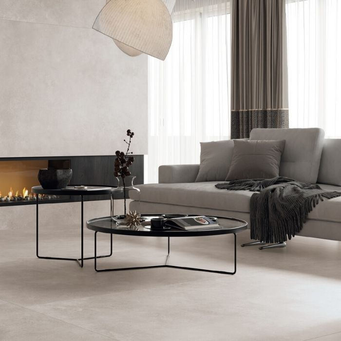 Neat white living room showcasing a cozy fireplace, chic coffee table, and concrete-effect floor tiles