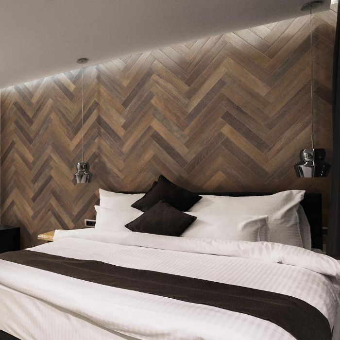 Stylish bed in a room with herringbone wall design