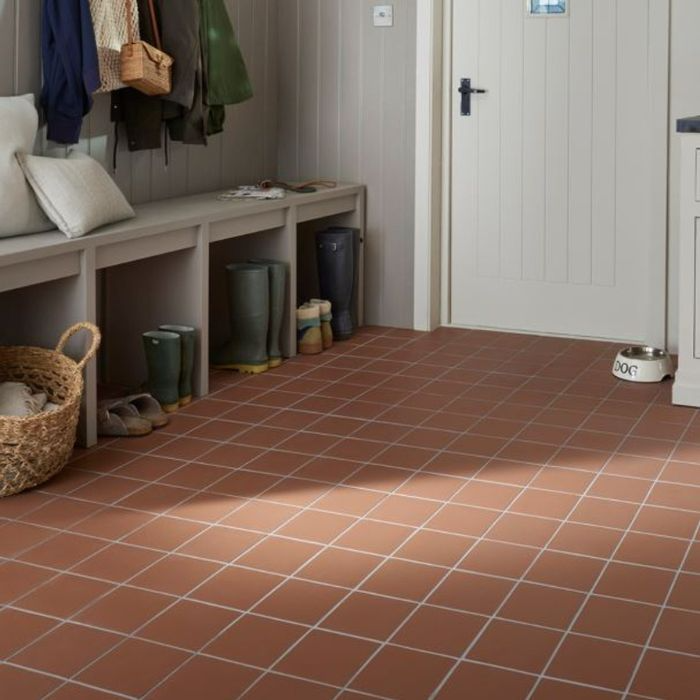 A hallway featuring a warm brown tiled floor