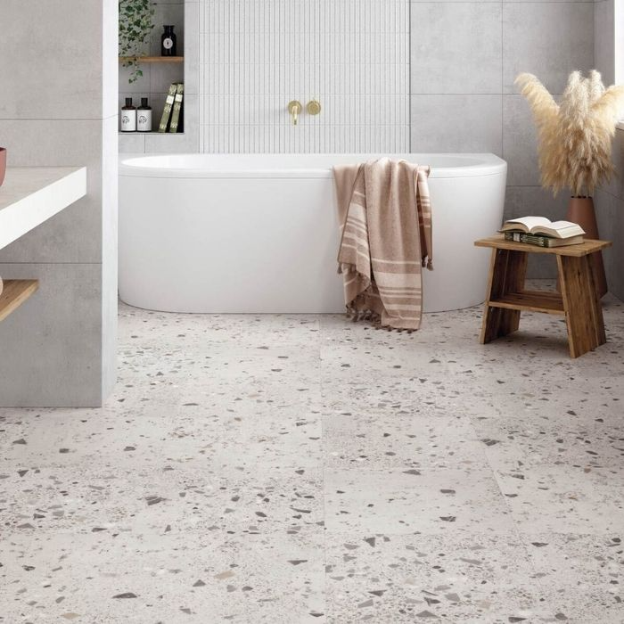 Minimalist bathroom design with a gleaming white tub, fresh white walls, and elegant vinyl flooring 