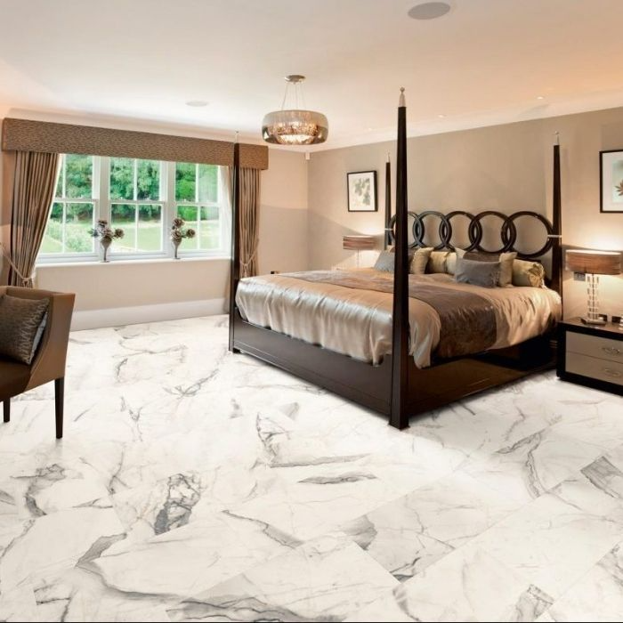 Contemporary bedroom showcasing luxurious marble tiles and a snug bed 