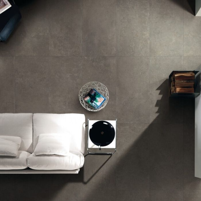 Overhead view of a living room with dark grey concrete-effect floor tiles and white sofa