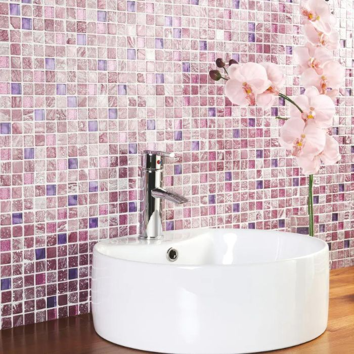 A bathroom showcasing a vibrant pink and purple mosaic tiled wall