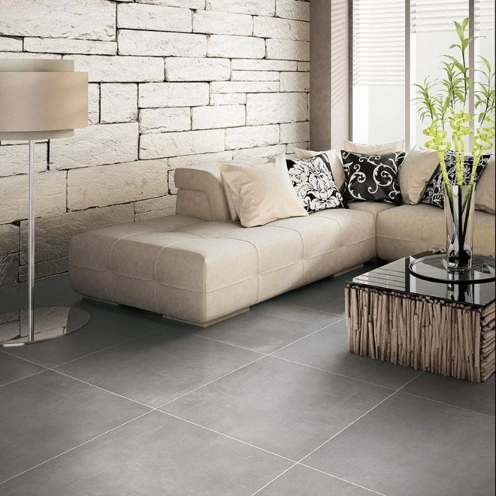 Contemporary living room with grey concrete-effect floor tiles and a stone accent wall