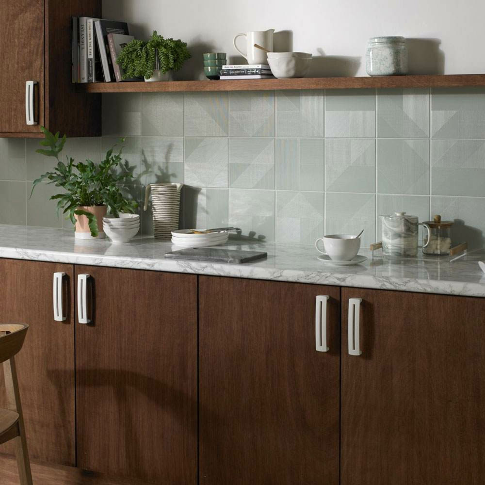 A warm kitchen setting with brown cabinets and wooden countertops, complemented by a tiled splashback