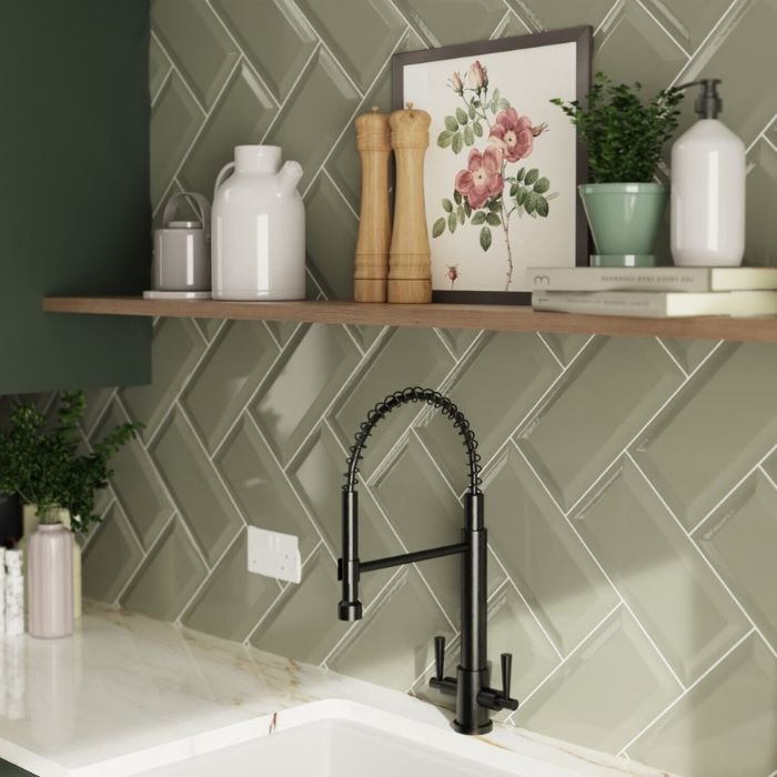 Stylish kitchen with green herringbone tiles