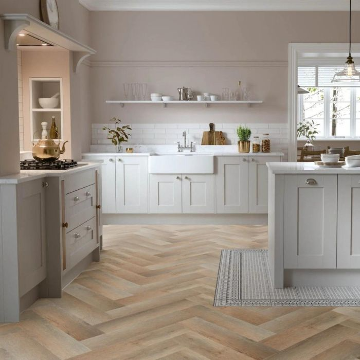 Elegant white kitchen with warm wooden herringbone tiles