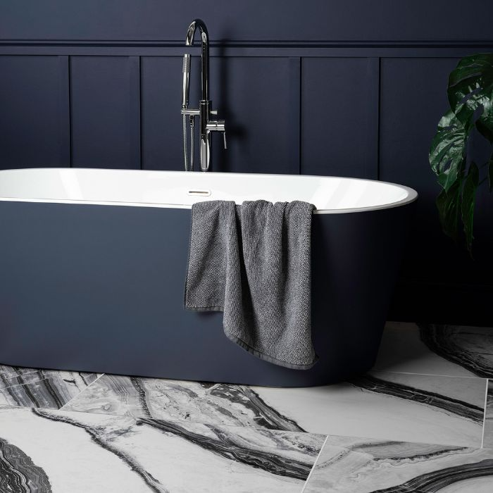 Dark blue walls and glazed white marble tiles in a bathroom interior