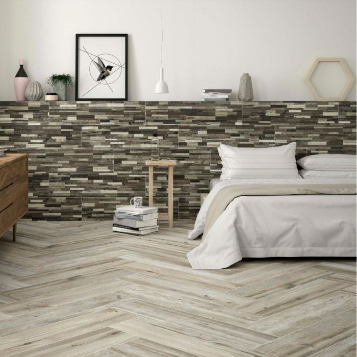 Cosy bedroom with wood-effect herringbone floor tiles and bed