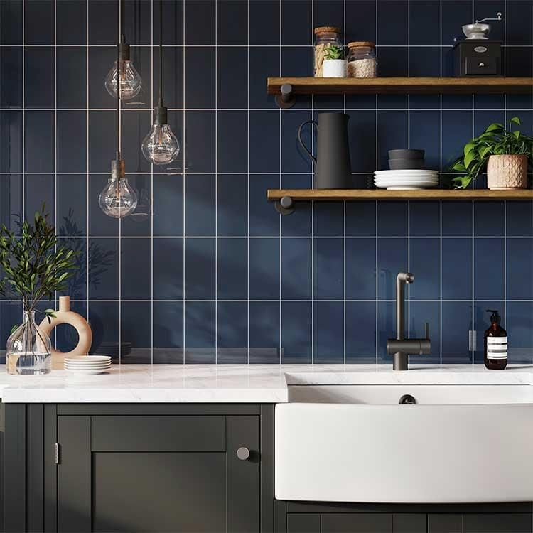 Kitchen setting with blue tiled walls featuring sink and shelves