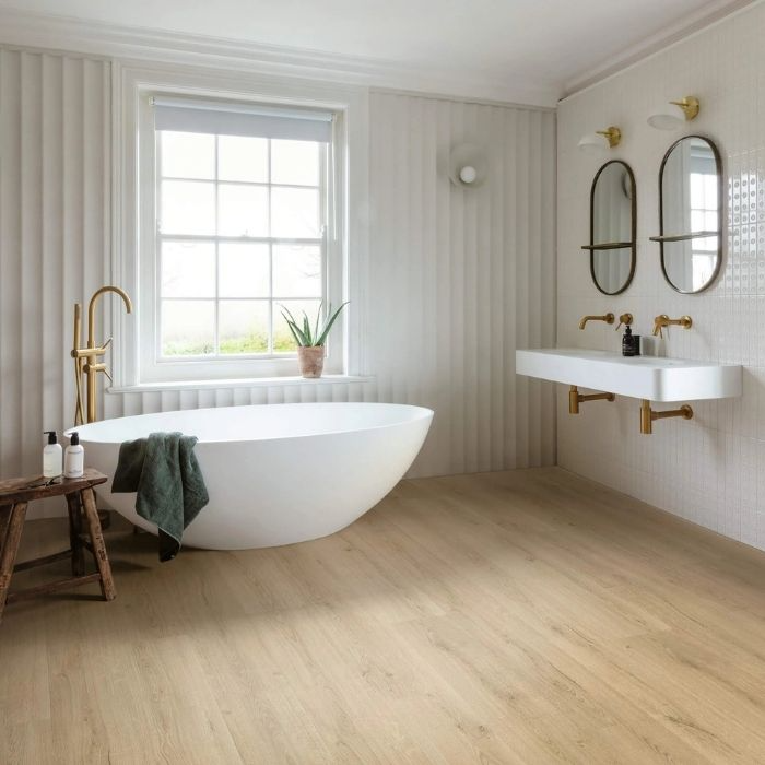 A serene white bathroom featuring wooden vinyl flooring and a stylish bathtub 