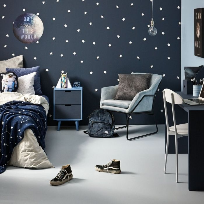 Stylish bedroom with navy blue polka dot walls, showcasing a comfy bed and white vinyl floor tiles