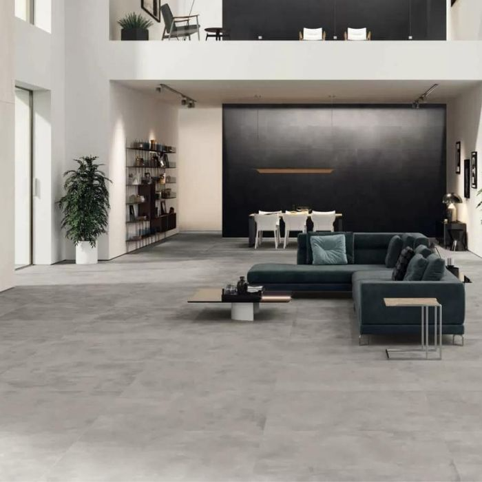 Spacious living room with grey concrete-effect floor tiles, dark accent wall, and modern furniture