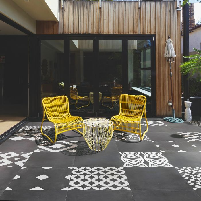 Monochrome outdoor lounge area with vibrant chairs