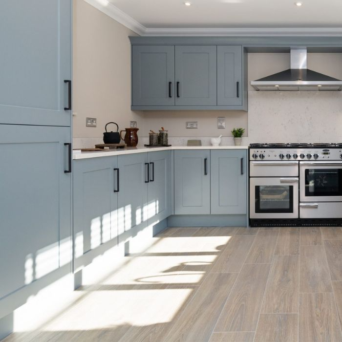 Kitchen with ocean-blue cabinets and warm wood flooring