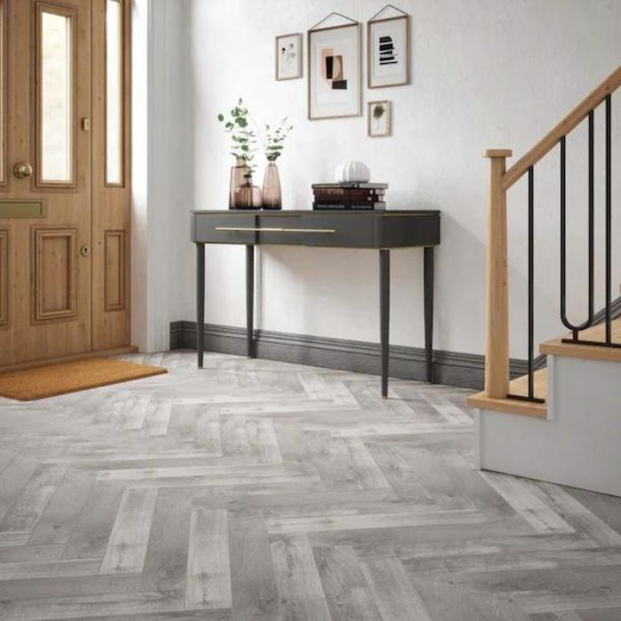 A sleek hallway lined with sophisticated grey herringbone tiles