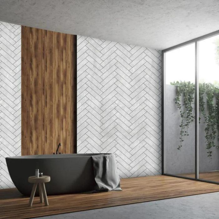 A modern bathroom with a white herringbone wall and wood-effect floor