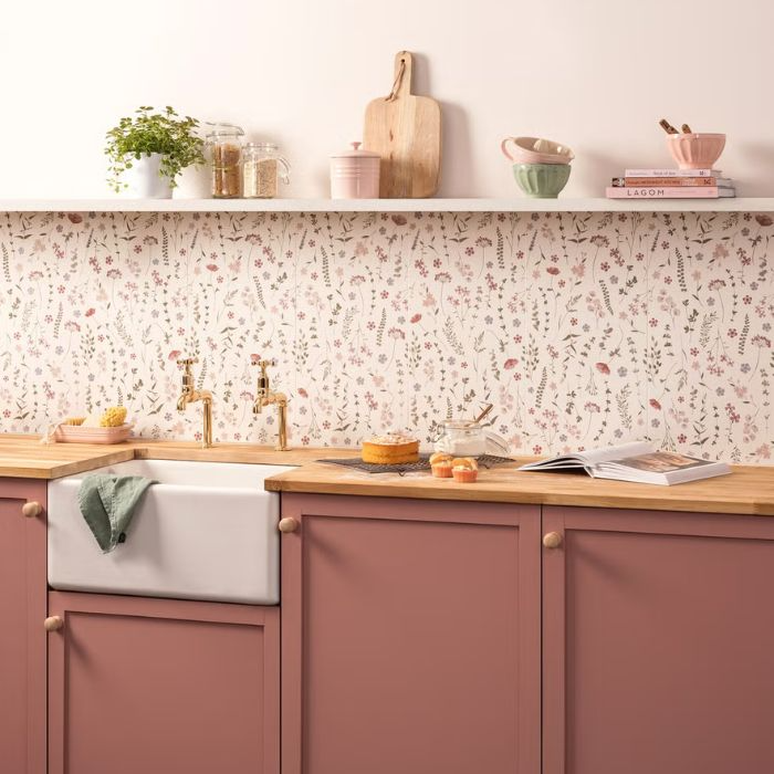 Charming kitchen with pink cupboards and floral backsplash