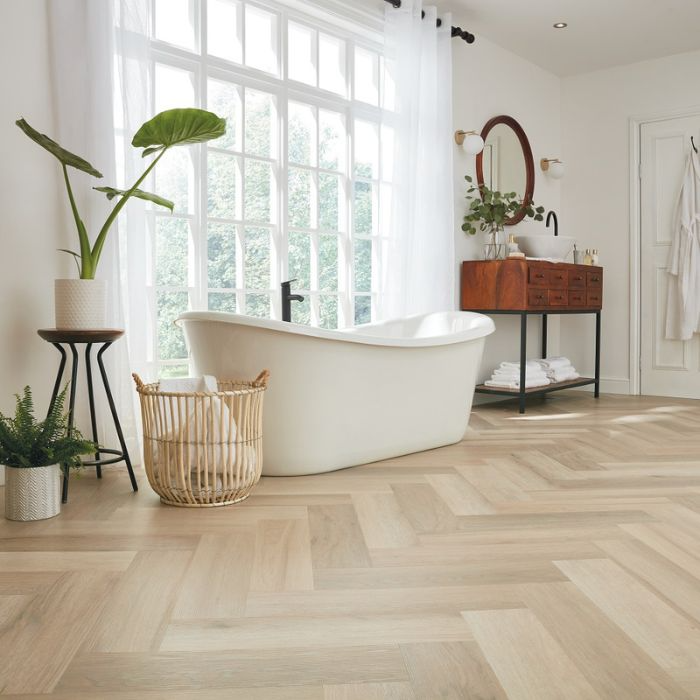 Bright bathroom featuring tub with wooden herringbone floors