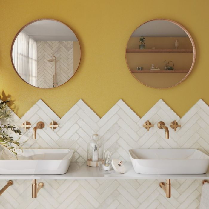 Stylish yellow-themed bathroom with dual sinks and herringbone tile work