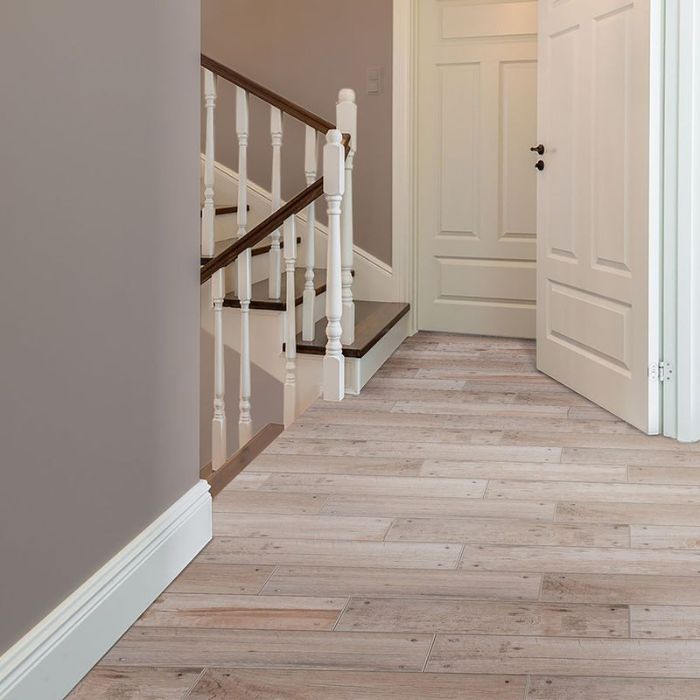 Bright and airy corridor with sleek wooden flooring and a charming stairway