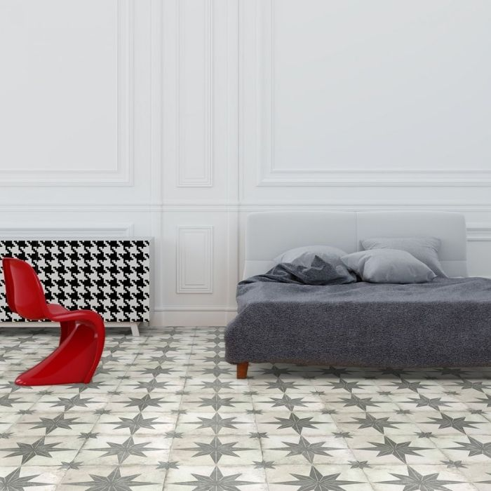 A minimalist bedroom featuring a neatly made bed and a stylish bedside table, complemented by patterned floor tiles 