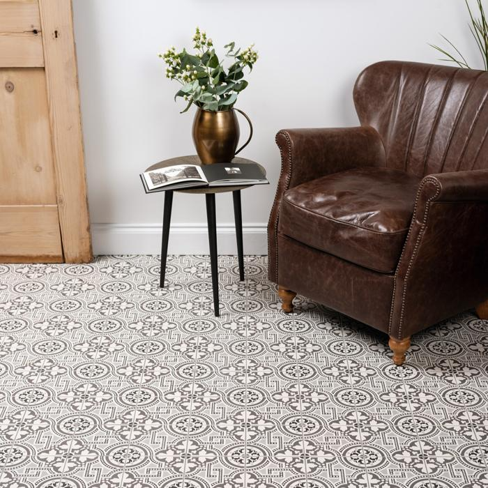 A living room scene with a brown leather chair and a vase, set on black and white Victorian tiles