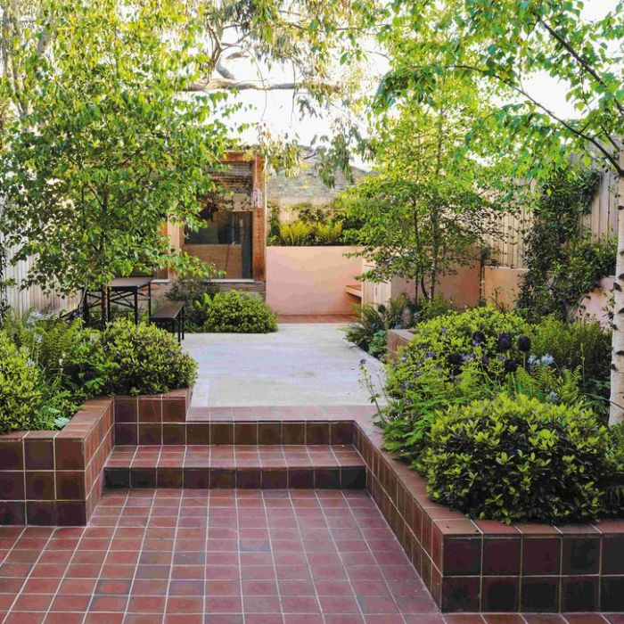 Quaint backyard with red tiles and lush green plants