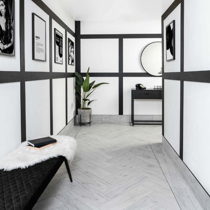 A visually striking hallway with monochromatic tiling and a chic bench, perfect for a waiting area