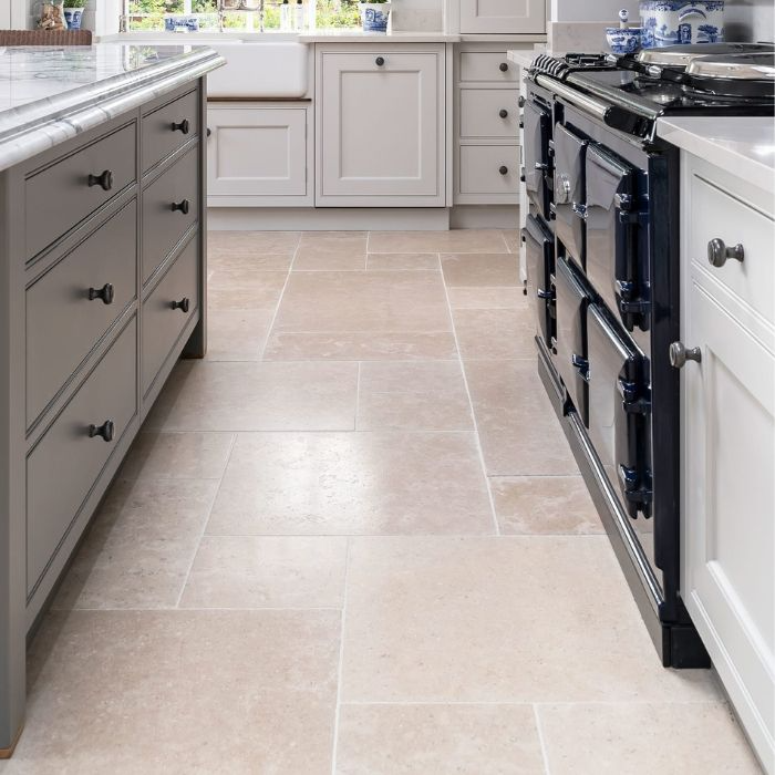 Modern kitchen with white stove and cabinets on stone floor