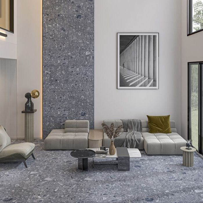 Living room with grey terrazzo floor tiles, beige sofa, and tall windows