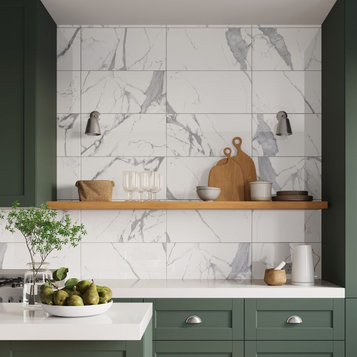 Green cabinetry contrasted with striking marble wall tiles