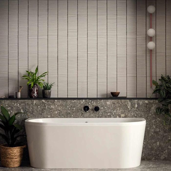 Modern bathroom interior with white bathtub and matchstick mosaic wall tiles