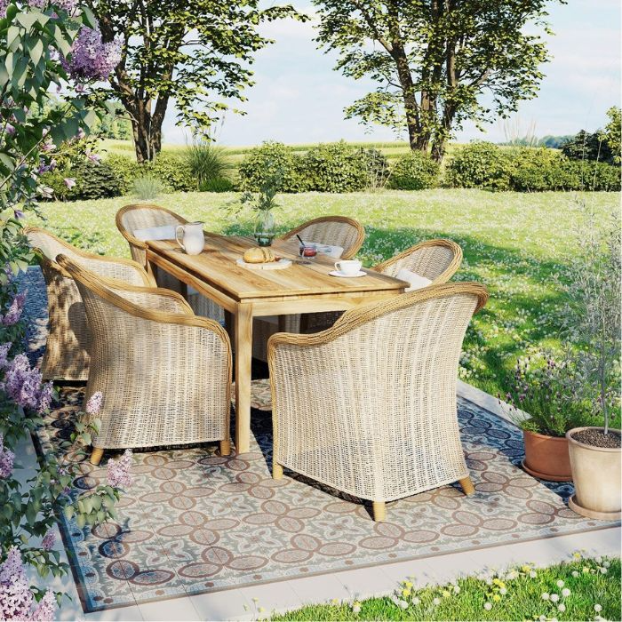 A garden dining set with wicker chairs and a table on patterned outdoor tiles